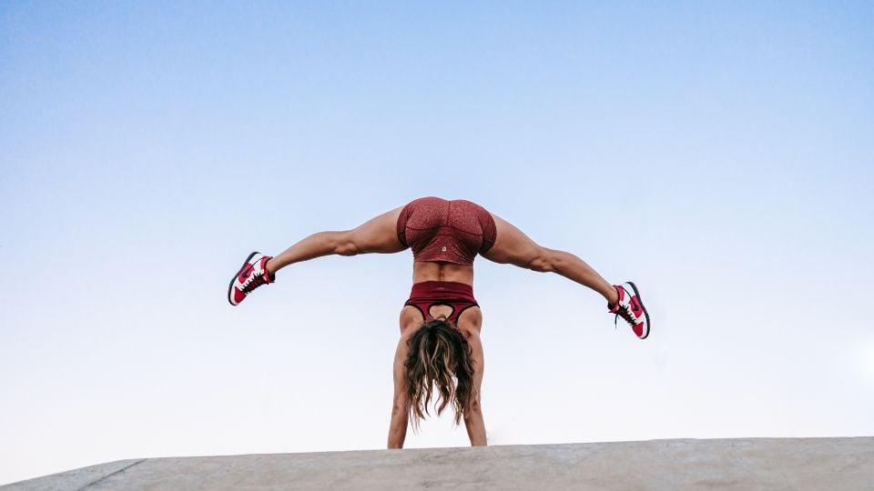 Vanja from Moves Method in a split handstand.