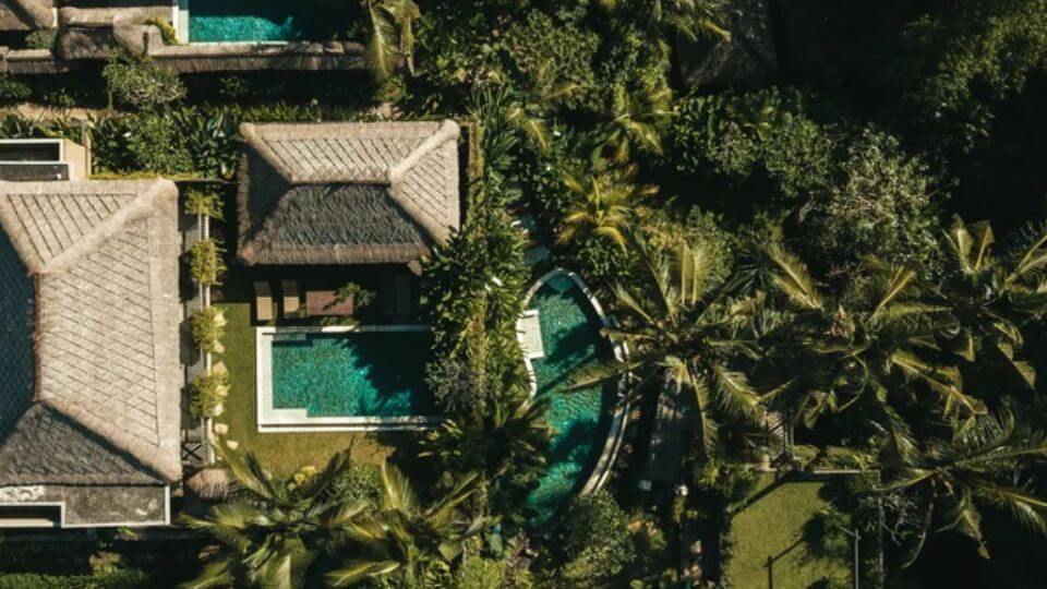 A spectacular overhead view of Ubud Nyuh Bali Resort with swimming pools and lush greenery.