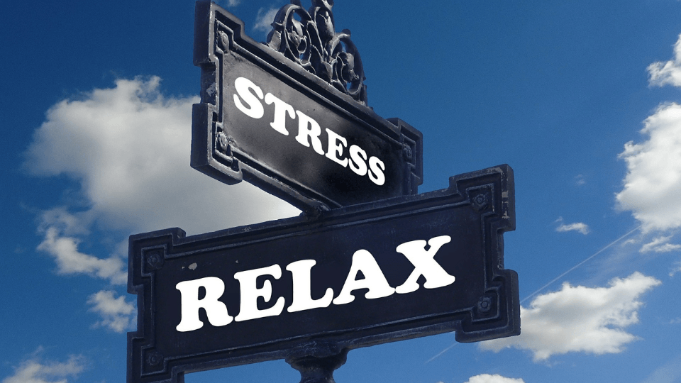 Signs against a blue sky showing stress one way and relax the other