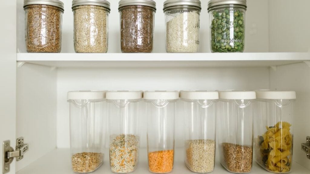 Jars or grains and legumes in a pantry as good preparation for having the ingredients on hand for your plant-based meals.
